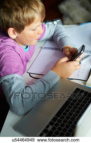Boy Using Mobile Phone Instead Of Studying In Bedroom View Large Photo Image Stock Photo - Boy Using Mobile Phone Instead Of Studying In Bedroom . Fotosearch