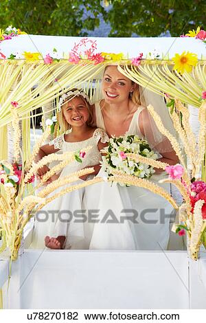 Stock Image - Bride And Bridesmaid Sitting Under Decorated Canopy. Fotosearch