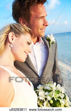 Stock Image - Bride And Groom Getting Married In Beach Ceremony. Fotosearch