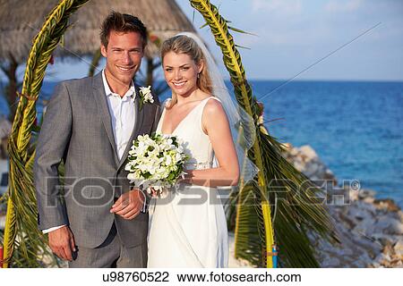 Stock Image - Bride And Groom Getting Married In Beach Ceremony. Fotosearch