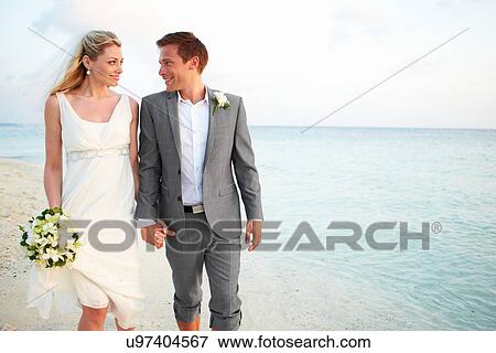 Stock Photo - Bride And Groom Getting Married In Beach Ceremony. Fotosearch