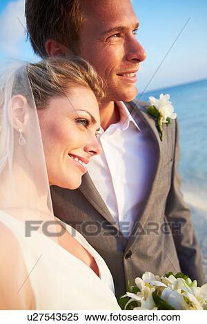 Stock Photography - Bride And Groom Getting Married In Beach Ceremony. Fotosearch