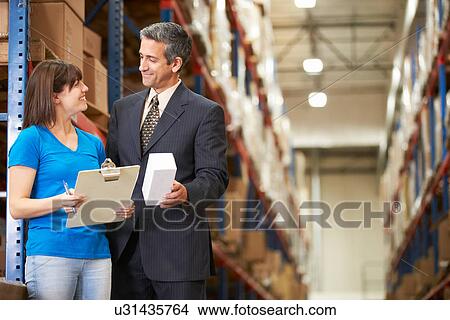 Businessman And Female Worker In Distribution Warehouse View Large Photo Image Picture - Businessman And Female Worker In Distribution Warehouse. Fotosearch