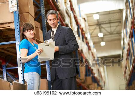 Businessman And Female Worker In Distribution Warehouse View Large Photo Image Stock Image - Businessman And Female Worker In Distribution Warehouse. Fotosearch