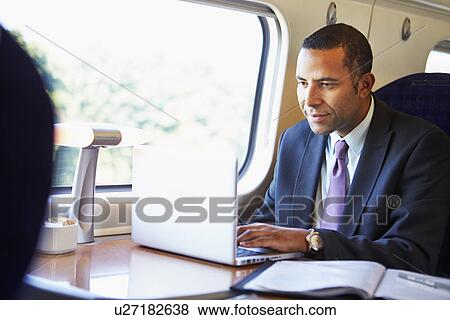 Businessman Commuting To Work On Train And Using Laptop View Large Photo Image Stock Photo - Businessman Commuting To Work On Train And Using Laptop. Fotosearch