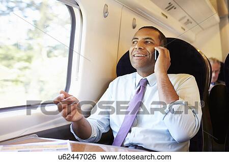 Businessman Commuting To Work On Train Using Mobile Phone View Large Photo Image Stock Photograph - Businessman Commuting To Work On Train Using Mobile Phone. Fotosearch