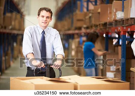 Businessman Pulling Pallet In Warehouse View Large Photo Image Stock Image - Businessman Pulling Pallet In Warehouse. Fotosearch