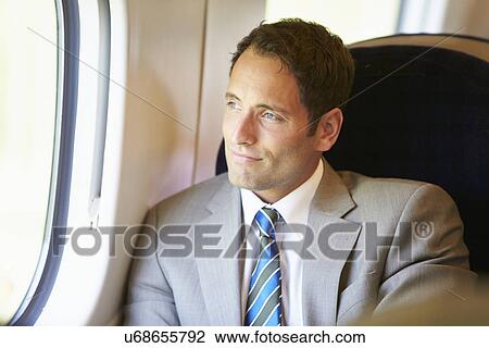 Stock Image - Businessman Relaxing On Train Journey. Fotosearch