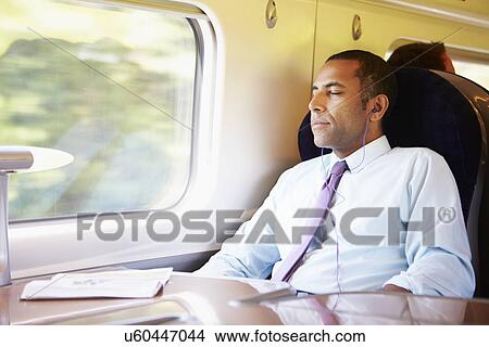 Businessman Relaxing On Train Listening To Music View Large Photo Image Picture - Businessman Relaxing On Train Listening To Music. Fotosearch