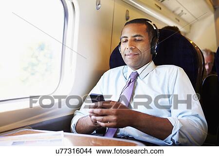 Businessman Relaxing On Train Listening To Music View Large Photo Image Picture - Businessman Relaxing On Train Listening To Music. Fotosearch