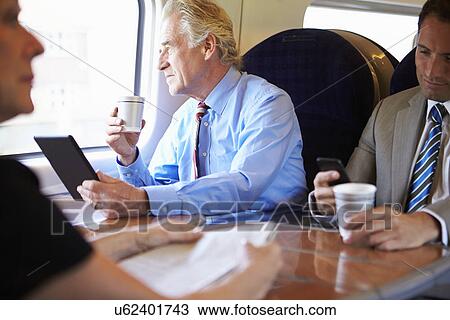 Stock Image - Businessman Relaxing On Train With Cup Of Coffee . Fotosearch