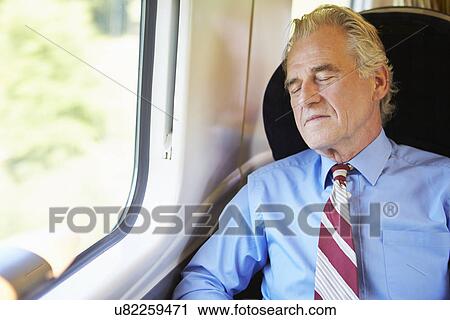 Stock Image - Businessman Resting On Train. Fotosearch