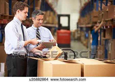 Picture - Businessmen Checking Boxes With Digital Tablet And Scanner. Fotosearch