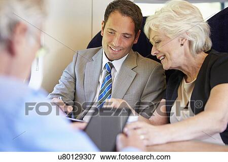 Stock Photo - Businesspeople Having Meeting On Train. Fotosearch