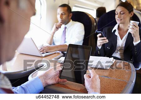 Businesspeople On Train Using Digital Devices View Large Photo Image Stock Photo - Businesspeople On Train Using Digital Devices. Fotosearch