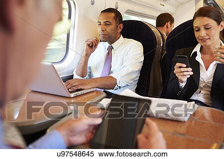 Businesspeople On Train Using Digital Devices View Large Photo Image Stock Photography - Businesspeople On Train Using Digital Devices. Fotosearch