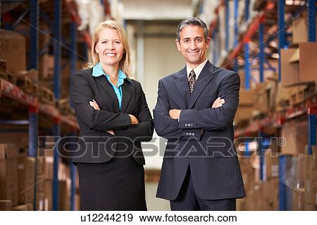 Businesswoman And Businessman In Distribution Warehouse View Large Photo Image Stock Photo - Businesswoman And Businessman In Distribution Warehouse. Fotosearch