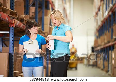 Businesswoman And Female Worker In Distribution Warehouse View Large Photo Image Stock Photo - Businesswoman And Female Worker In Distribution Warehouse. Fotosearch