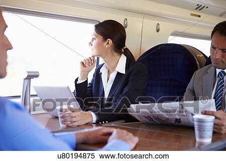 Stock Photography - Businesswoman Commuting To Work On Train And Using Laptop. Fotosearch