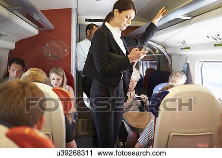 Businesswoman Using Mobile Phone On Busy Commuter Train View Large Photo Image Stock Image - Businesswoman Using Mobile Phone On Busy Commuter Train. Fotosearch