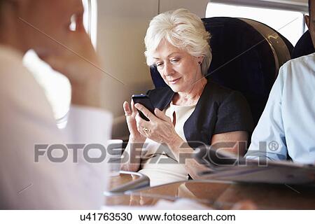 Businesswoman Using Mobile Phone On Busy Commuter Train View Large Photo Image Stock Image - Businesswoman Using Mobile Phone On Busy Commuter Train. Fotosearch