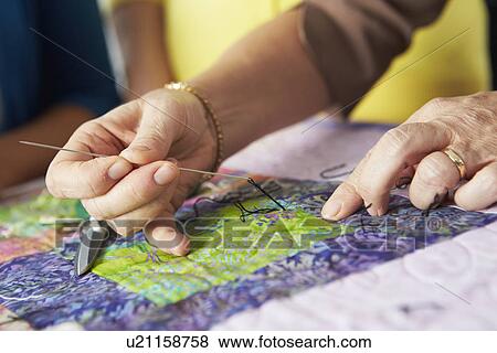 Stock Photo - Close Up Of Woman's Hand Sewing Quilt. Fotosearch