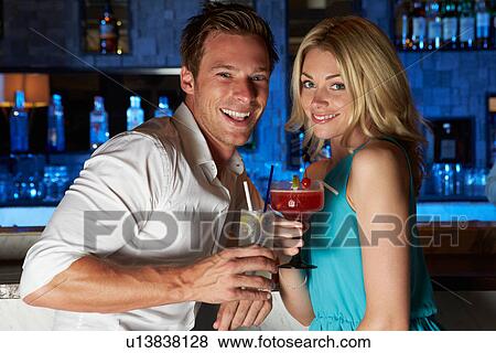 Stock Photo - Couple Enjoying Cocktail In Bar. Fotosearch