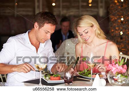 Stock Photo - Couple Enjoying Meal In Restaurant. Fotosearch