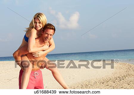 Stock Photo - Couple Having Fun On Tropical Beach Holiday. Fotosearch