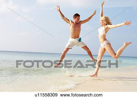 Couple Jumping In The Air On Tropical Beach View Large Photo Image Stock Photo - Couple Jumping In The Air On Tropical Beach. Fotosearch