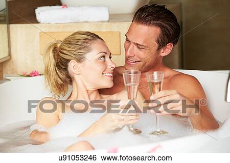 Stock Photograph - Couple Relaxing In Bath Drinking Champagne Together. Fotosearch