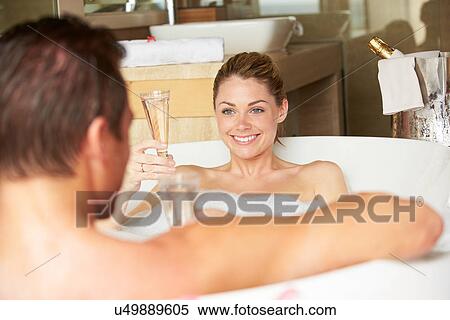 Stock Photography - Couple Relaxing In Bath Drinking Champagne Together. Fotosearch