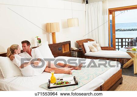 Picture - Couple Relaxing In Hotel Room Wearing Robes. Fotosearch