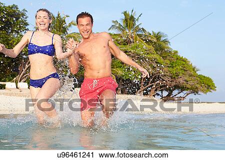 Couple Splashing In Sea On Tropical Beach Holiday View Large Photo Image Stock Image - Couple Splashing In Sea On Tropical Beach Holiday. Fotosearch