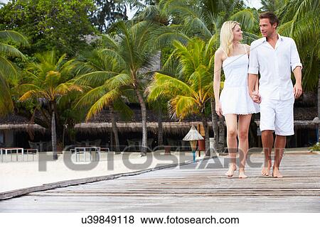 Stock Photo - Couple Walking On Wooden Jetty. Fotosearch