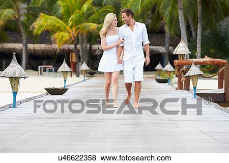Stock Photo - Couple Walking On Wooden Jetty. Fotosearch