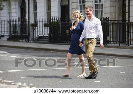 Picture - Couple With Pregnant Wife Crossing City Road. Fotosearch