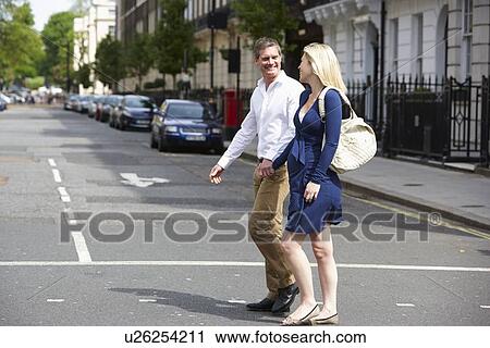 Stock Image - Couple With Pregnant Wife Crossing City Road. Fotosearch