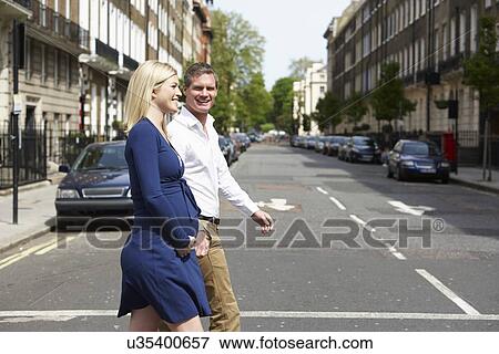 Stock Photo - Couple With Pregnant Wife Crossing City Road. Fotosearch