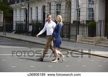 Stock Photo - Couple With Pregnant Wife Crossing City Road. Fotosearch