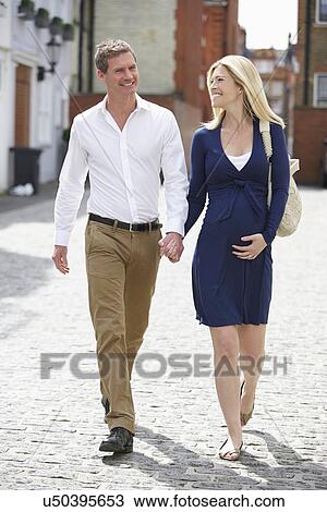 Couple With Pregnant Wife Walking Along Urban Sidewalk View Large Photo Image Stock Image - Couple With Pregnant Wife Walking Along Urban Sidewalk. Fotosearch