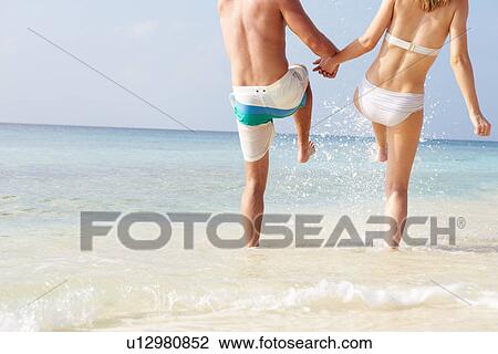 Detail Of Couple Splashing In Sea On Beach Holiday View Large Photo Image Stock Image - Detail Of Couple Splashing In Sea On Beach Holiday. Fotosearch