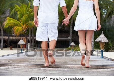 Stock Image - Detail Of Couple Walking On Wooden Jetty. Fotosearch