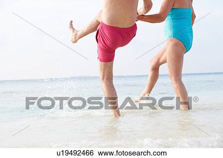 Detail Of Senior Couple Splashing In Sea On Beach Holiday View Large Photo Image Stock Photograph - Detail Of Senior Couple Splashing In Sea On Beach Holiday. Fotosearch