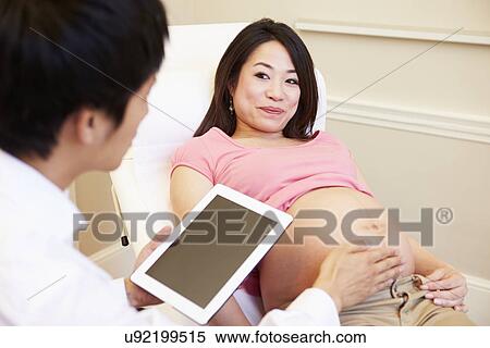 Doctor Using Digital Tablet In Meeting With Pregnant Woman View Large Photo Image Stock Photography - Doctor Using Digital Tablet In Meeting With Pregnant Woman. Fotosearch