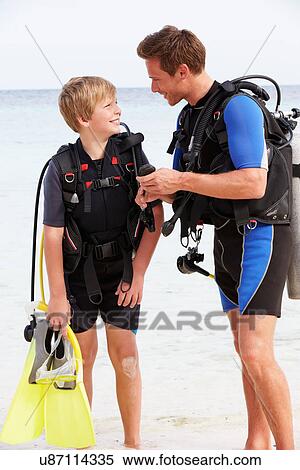 Stock Photography - Father And Son With Scuba Diving Equipment On Beach Holiday. Fotosearch