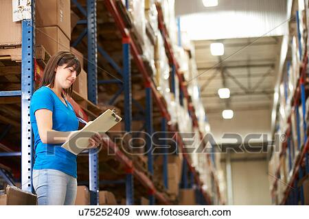 Stock Photo - Female Worker In Distribution Warehouse. Fotosearch