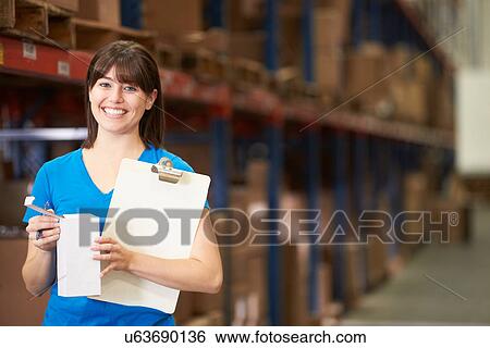Stock Photograph - Female Worker In Distribution Warehouse. Fotosearch