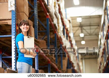 Stock Photography - Female Worker In Distribution Warehouse. Fotosearch