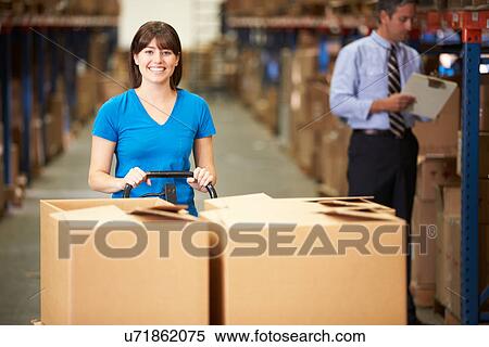 Stock Photography - Female Worker Pulling Pallet In Warehouse. Fotosearch